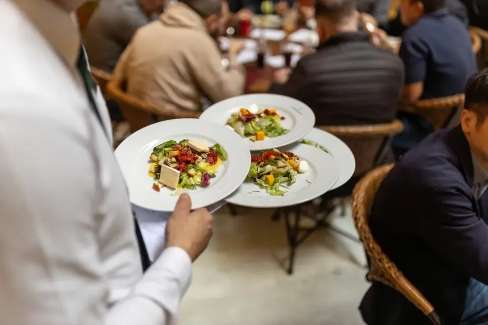 レストランで料理を運ぶ店員